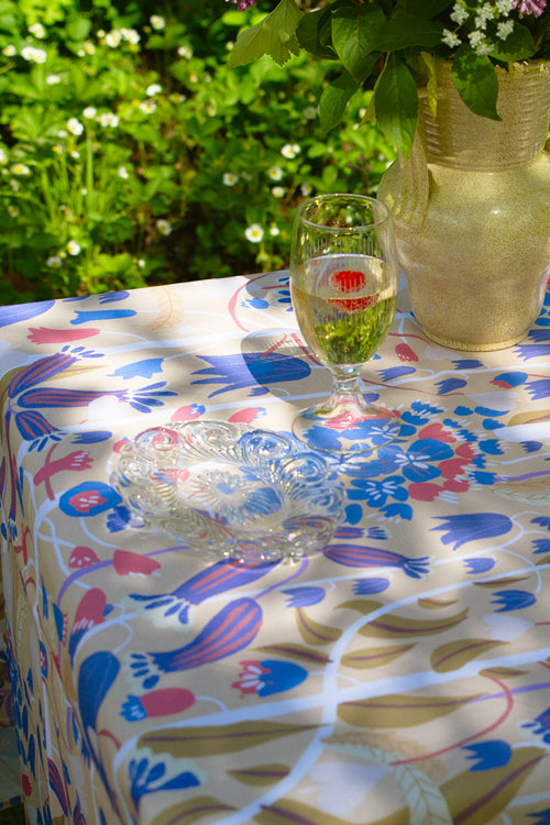 I trädgården är ett bord dukat till fest med  blommig duk svensk design av By Ulrika G