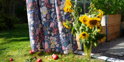 Blommig ljus bommullsgardin med designad av By Ulrika G hänger i växthuset