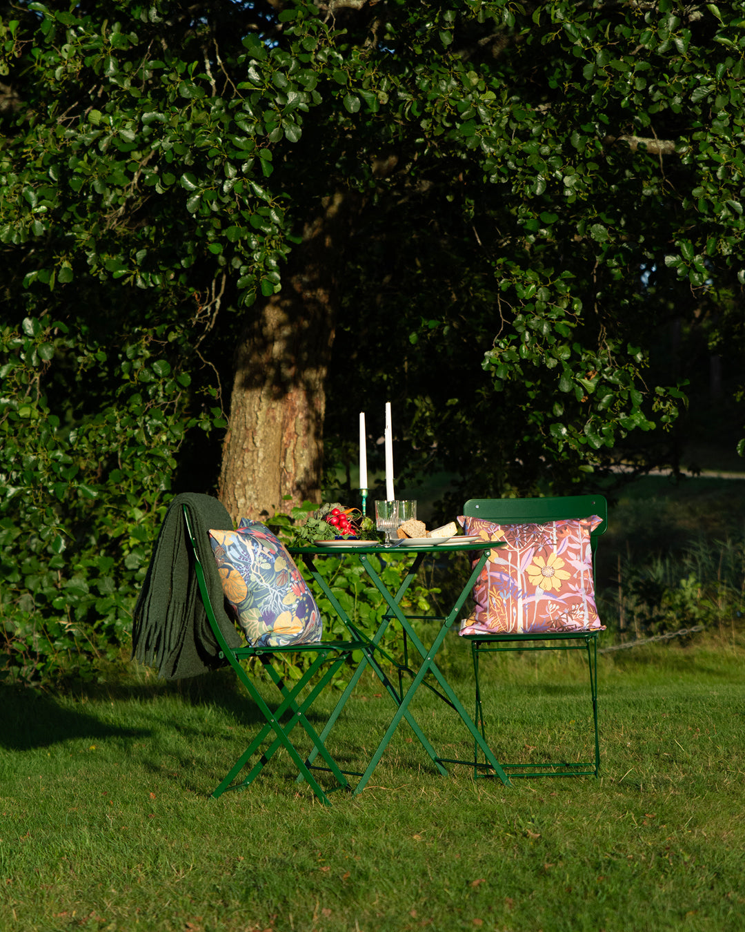Dukat för est i trädgården med blommiga mönnstrade kuddar svensk design av By Ulrika G