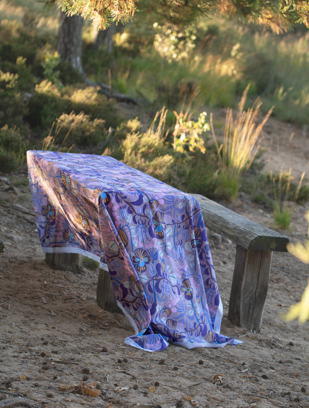 Ett träbord med blommigt tyg som duk -by Ulrika G