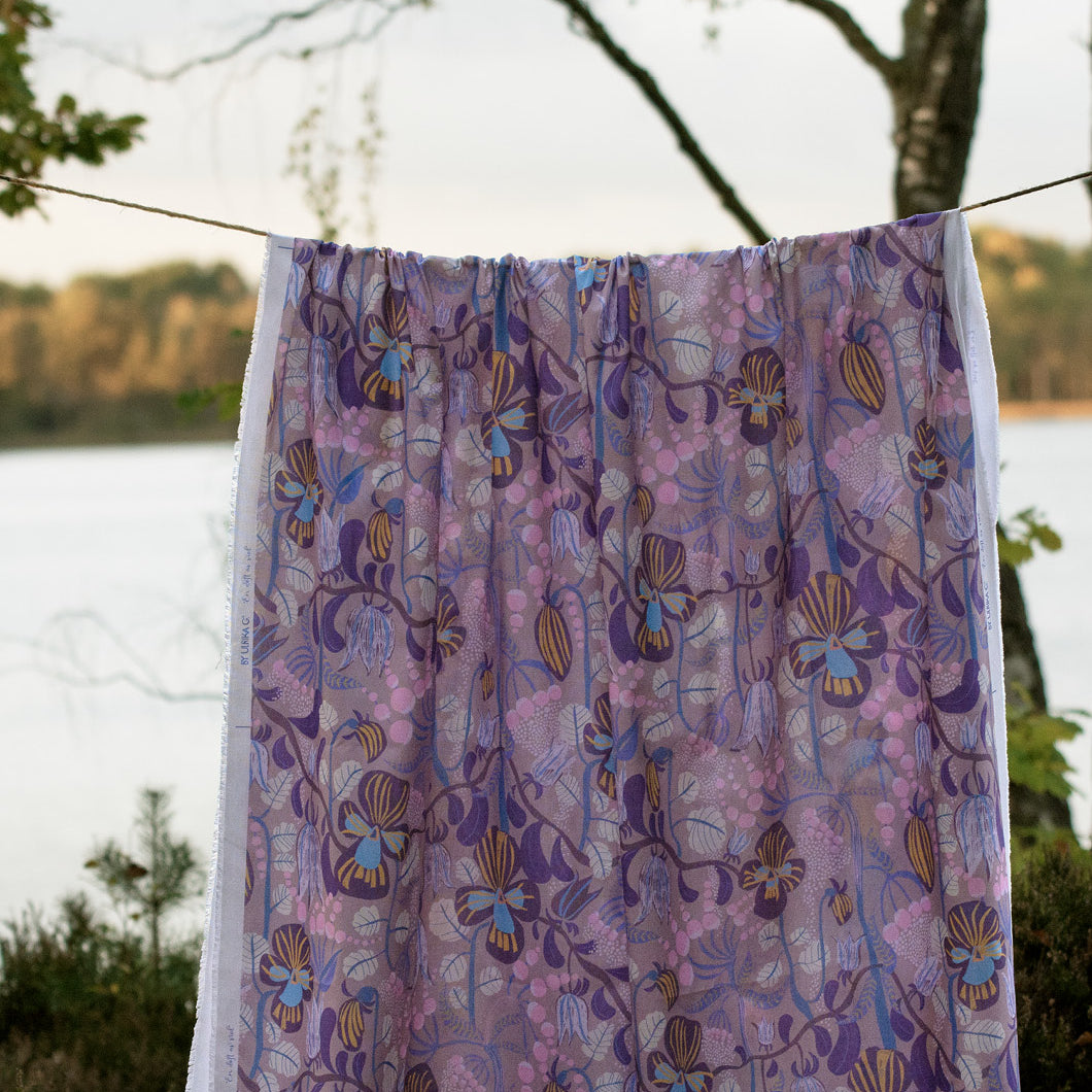 Blommigt tyg som hänger på en lina som en gardin. Design skapad av By Ulrika G