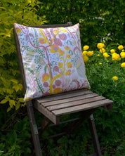 By Ulrika G - Kudde 45x45 cm med mönstret  En sommar i dalarna på en stol i en trädgård