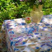 Blommig mönstrad duk ute i grönskan dukat till fest