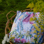 Blommig kuddfodral i en korg i trädgården