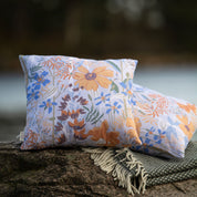 Blommig  mönstrad kudde i storleken 45x45 cm i svensk design By Ulrika G på en klippa