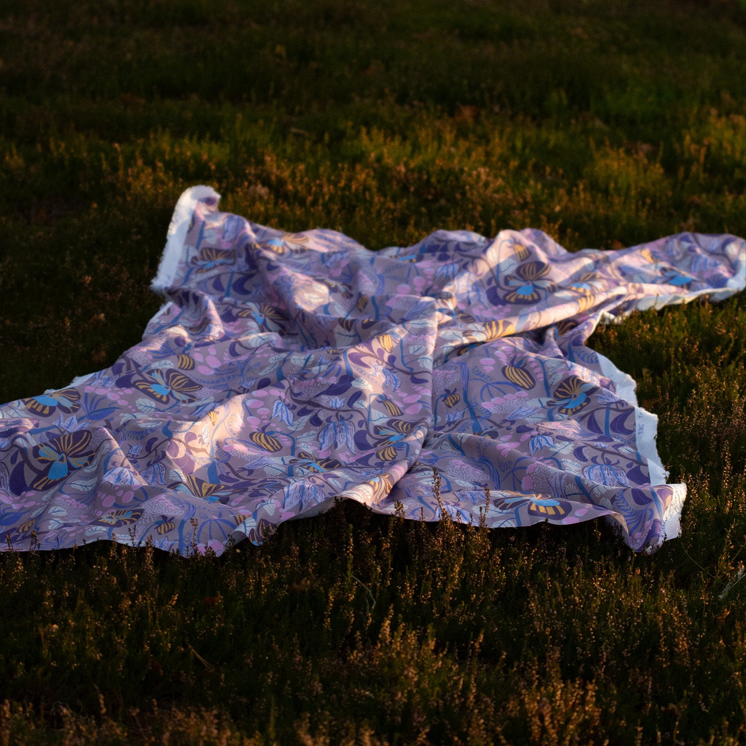 Mönstrat blommig tyg som ligger i ljungen