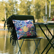 Blommig mönstrad kudde på en stol vid sjön 