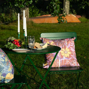 Mönstrade blommig kuddar vid ett bord dukat för middag.