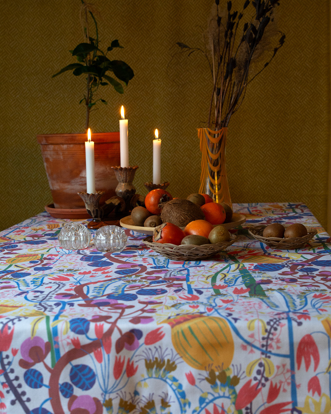 Bord med fruktfat ljusstake med levande ljus och blommig duk svensk design av By Ulrika G