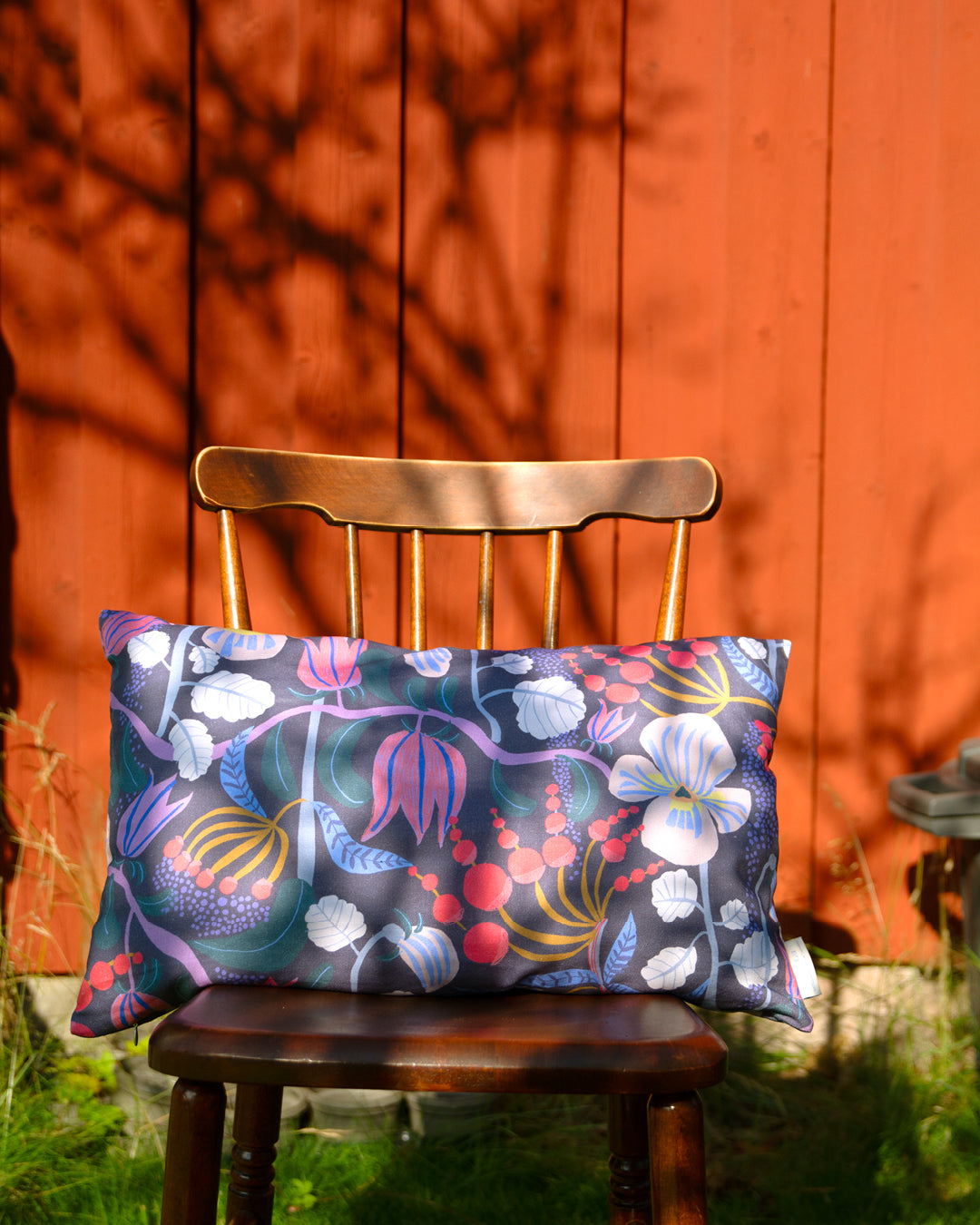 By Ulrika G Kudde 55x35 cm i Mönster En doft av viol mot en faluröd vägg.