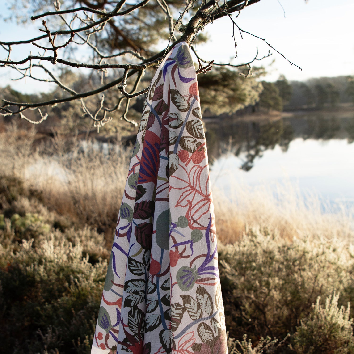 Blommigt mönstrat tyg som hänger ute i skogen på en gren