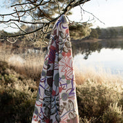 Blommigt mönstrat tyg som hänger ute i skogen på en gren