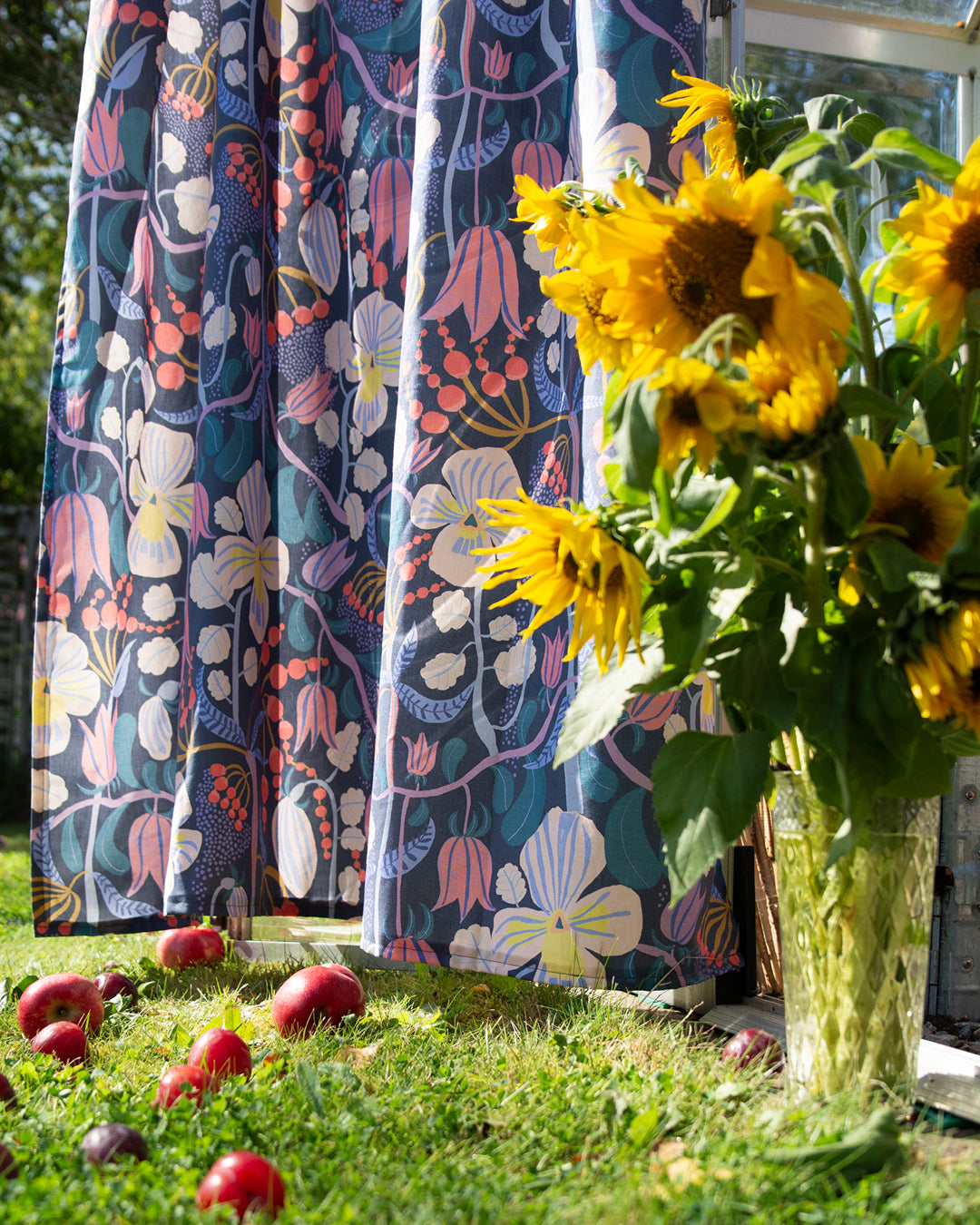 Mönstrad gardin svensk deisgn by Ulrika G med en vas solrosor